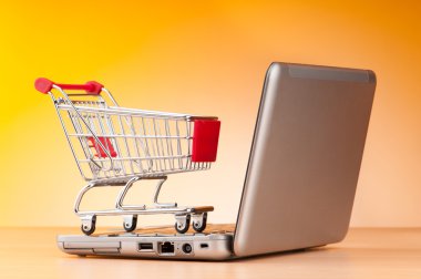 Internet online shopping concept with computer and cart clipart