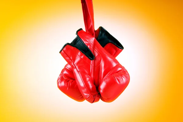 Rote Boxhandschuhe auf dem Hintergrund — Stockfoto