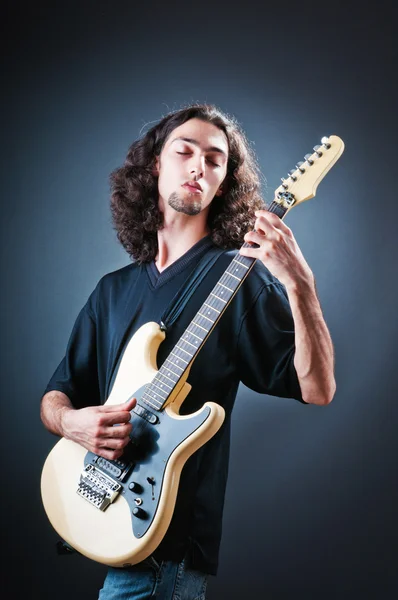 Guitar player against the dark background — Stock Photo, Image