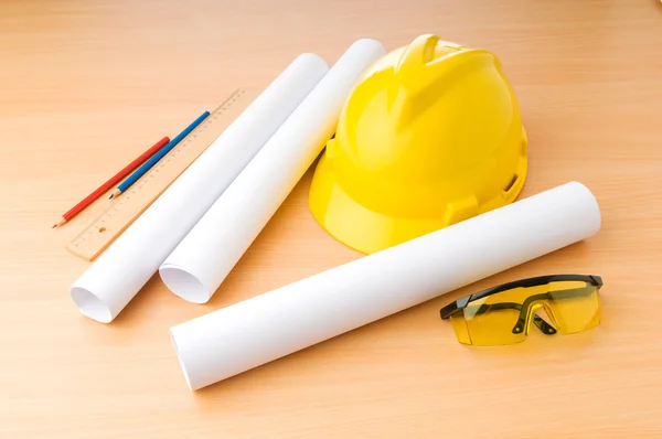 Drawings and hard hat on the desk — Stock Photo, Image