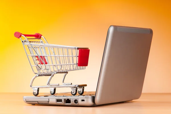 Internet concepto de compras en línea con ordenador y carrito Imágenes De Stock Sin Royalties Gratis