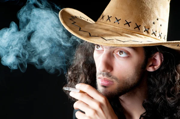 Muž v kravském klobouku kouření — Stock fotografie