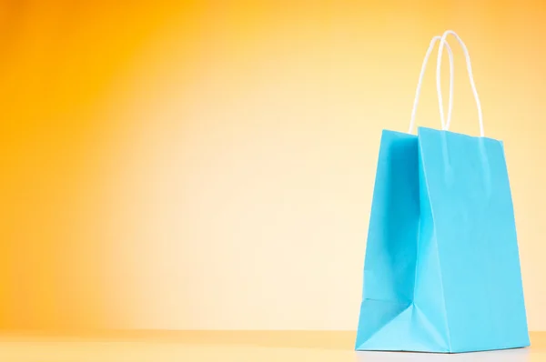 Colourful paper shopping bags against gradient background — Stock Photo, Image