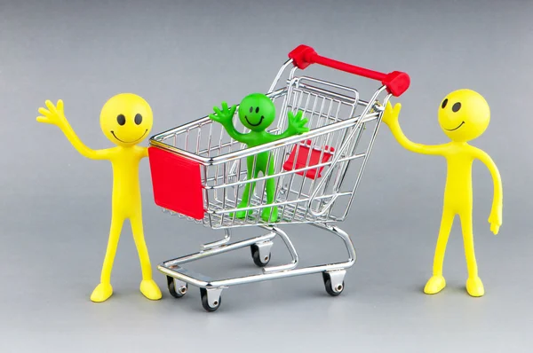 Shopping cart and happy smilies Royalty Free Stock Photos