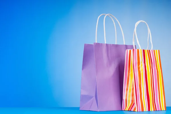 Kolorowe papierowe torby na zakupy przed tło gradientowe — Zdjęcie stockowe