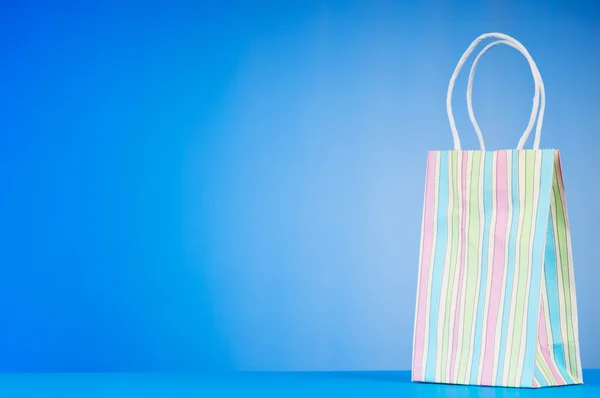 stock image Colourful paper shopping bags against gradient background