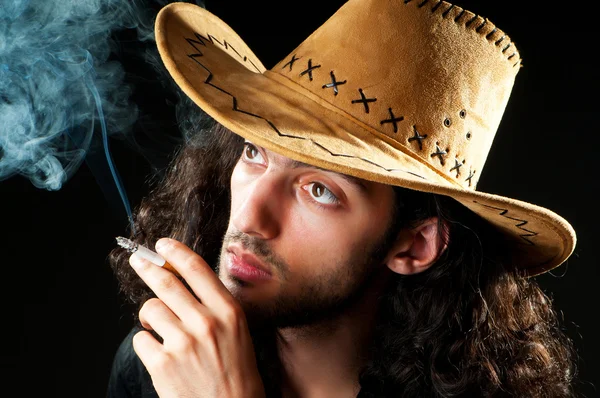 Człowiek w kapeluszu kowbojskim pali — Zdjęcie stockowe