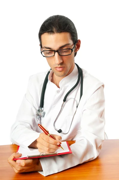 Доктор сидит за столом на белом — стоковое фото