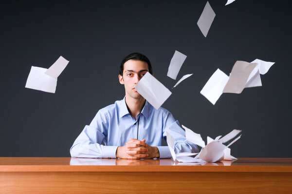 Летающая бумага и бизнесмен в офисе