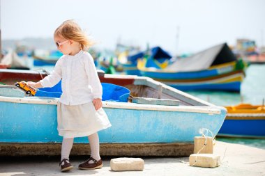 Little girl playing with toy bus clipart