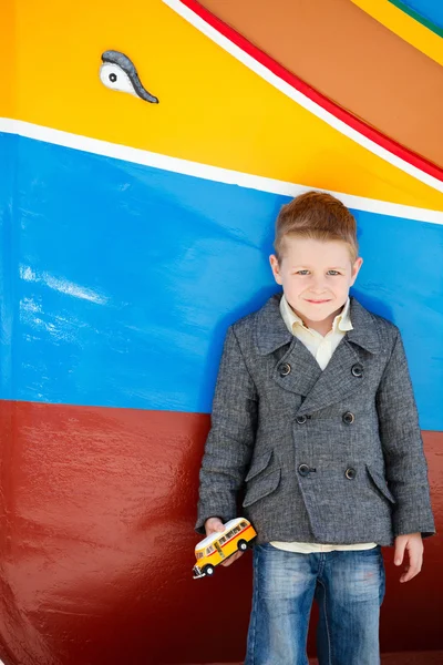 Boy near colorful boat — Stock Photo, Image