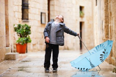 Cute boy on rainy day clipart