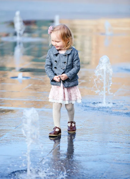 Kleines Mädchen spielt im Straßenbrunnen — Stockfoto