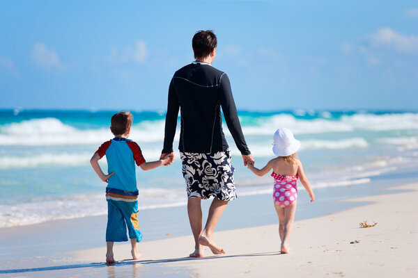 Father with his two kids on tropical beach vacation