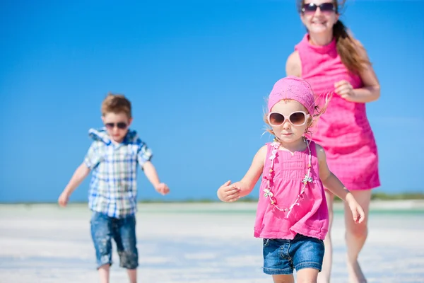 Matka i dzieci biegają na plaży — Zdjęcie stockowe