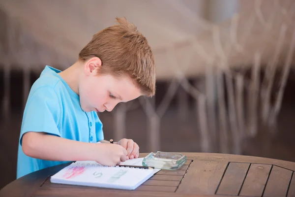 Хлопчик малює або пише — стокове фото