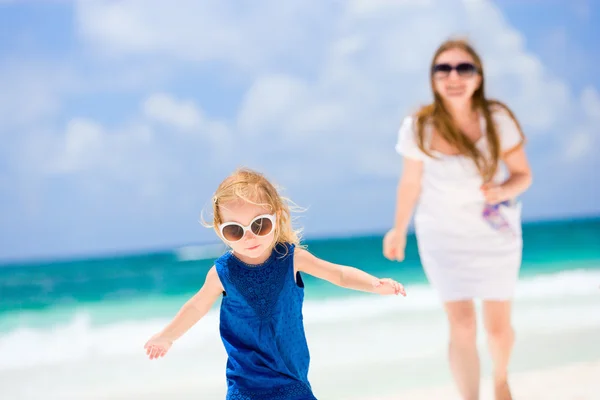 Мать и дочь бегут по пляжу — стоковое фото