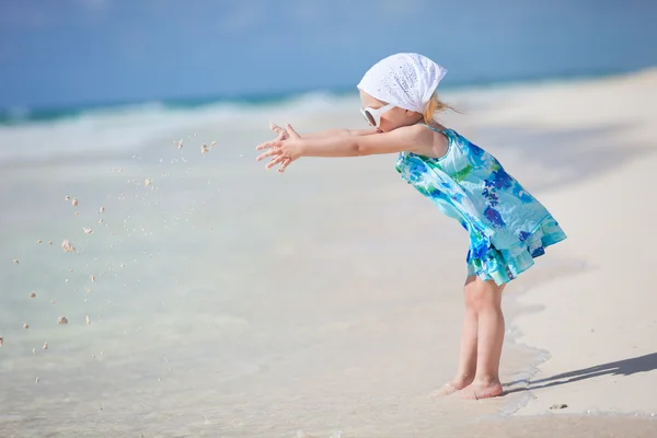 Маленькая игривая девочка на пляже — стоковое фото