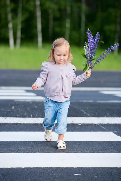 Маленькая девочка переходит дорогу — стоковое фото
