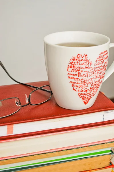 Hromadu starých knih, brýle a šálek čaje — Stock fotografie