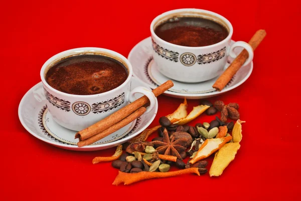 Black coffee and spices isolated on red — Stock Photo, Image