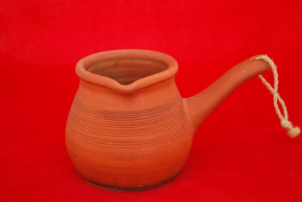 Old ceramic cezve isolated on red — Stock Photo, Image