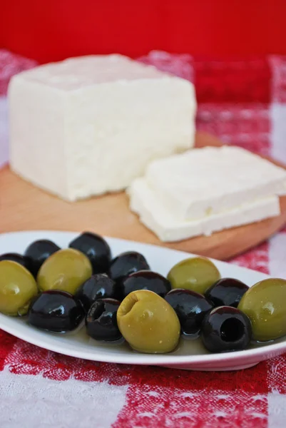 Still life of brynza cheese and olives on a kitchen towel — Stock Photo, Image