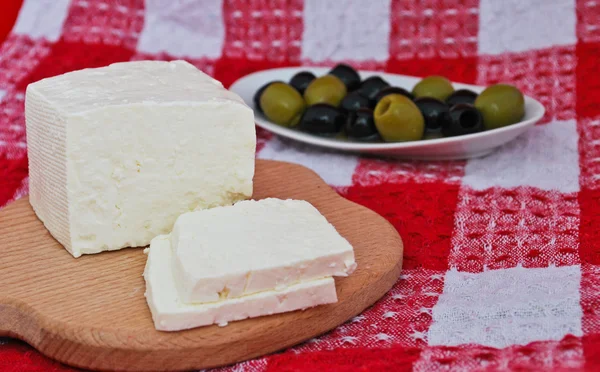 stock image Still life of brynza cheese and olives on a kitchen towel