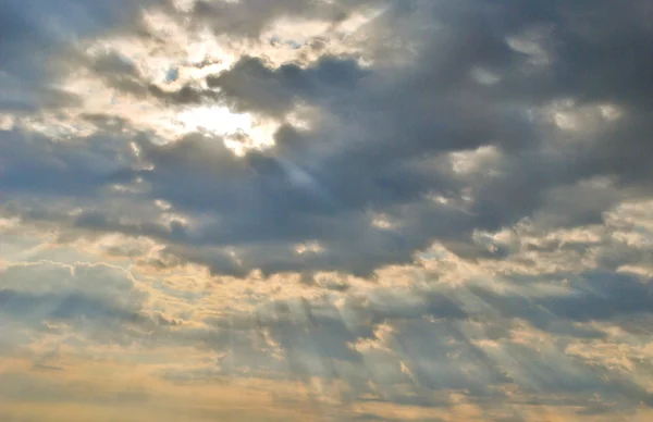 Ljus strålar lyser igenom mörka moln — Stockfoto