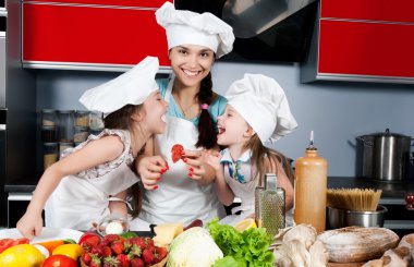 Mother and two daughters in the kitchen clipart
