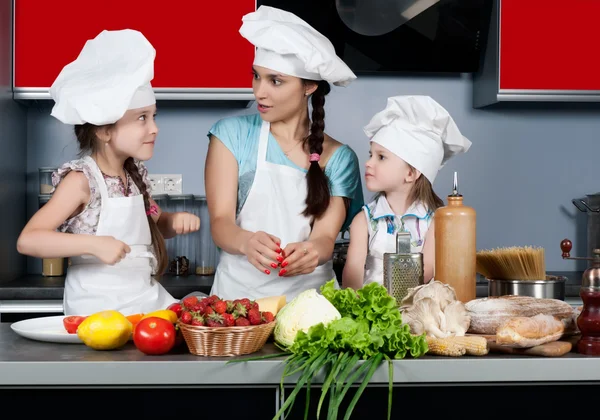 Mother and two daughters in the kitchen — Stock Photo, Image
