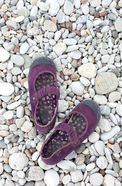 Plaj taşlar üzerinde kadın ayakkabı — Stok fotoğraf