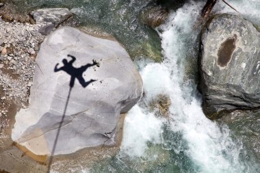 Falling bungee jumper shadow above mountain river clipart