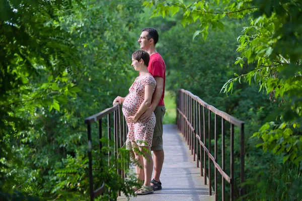 在桥上他怀孕的妻子与丈夫 — 图库照片