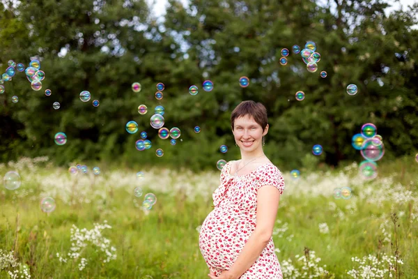 Zwangere vrouw met zeepbellen — Stockfoto
