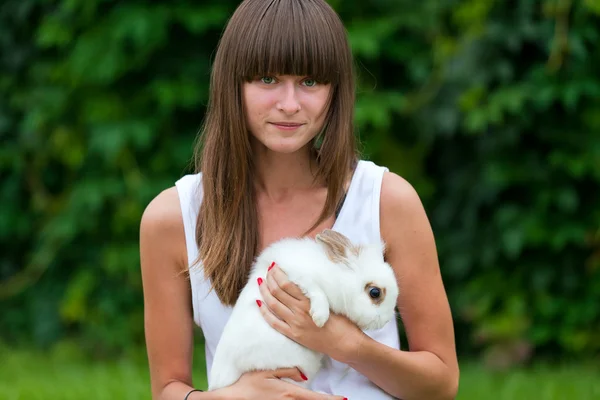 Adolescente chica sosteniendo conejo blanco — Foto de Stock
