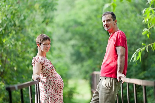 Husband with his pregnant wife on the bridge — Stock Photo, Image