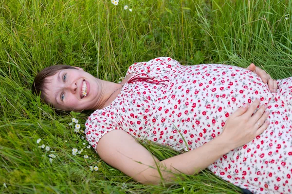 Pregnant woman lie in chamomile — Stock Photo, Image
