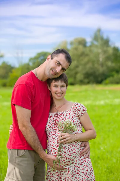 Koca hamile karısına sarılıyor. — Stok fotoğraf
