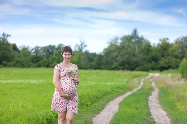 Femme enceinte avec des camomilles — Photo