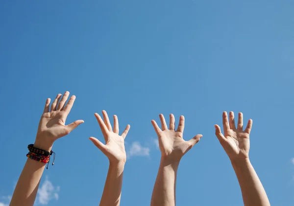 Las manos levantadas en el aire a través del cielo — Foto de Stock