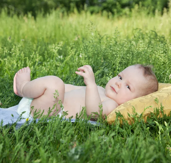 Baby ležela na polštáři v parku — Stock fotografie