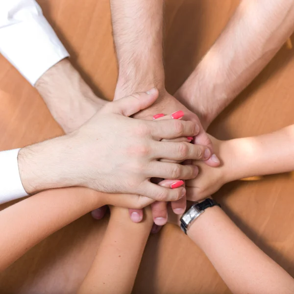 Office workers hold hands together — Stock Photo, Image