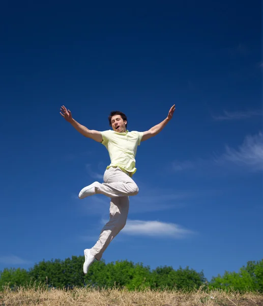 若い男が公園の丘の上にジャンプします。 — ストック写真