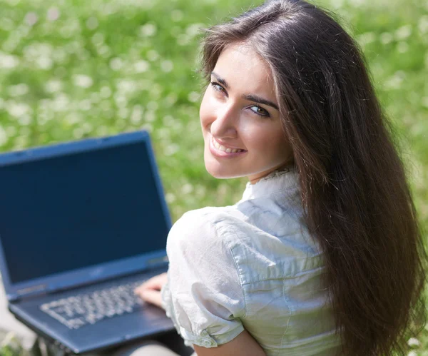 Γυναίκα με φορητό υπολογιστή που κάθονται στο χόρτο — Φωτογραφία Αρχείου