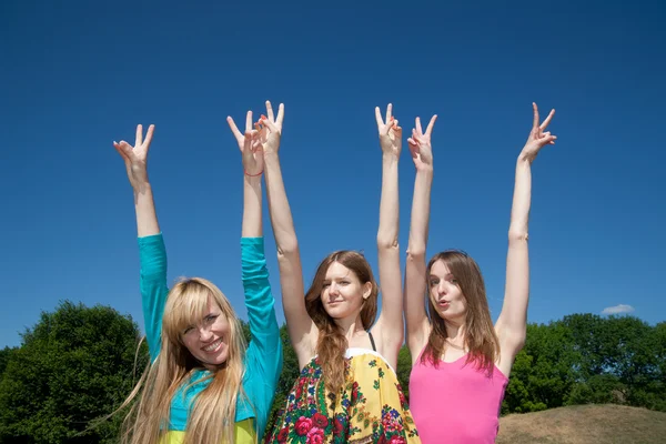 Grupa podnieść ręce w powietrze przez błękitne niebo — Zdjęcie stockowe