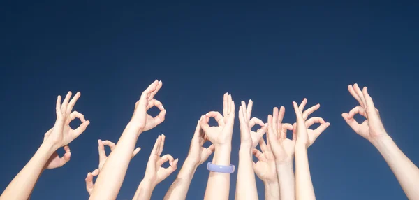 Raise hands across blue sky — Stock Photo, Image