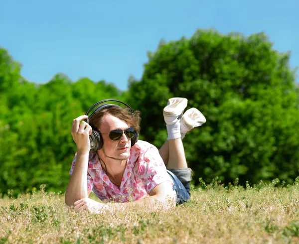 Ung man om på gräs — Stockfoto
