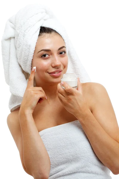 Belle donne che applicano crema cosmetica idratante sul viso . — Foto Stock