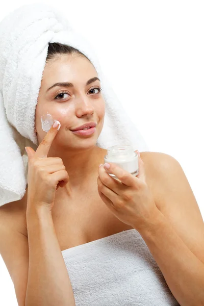Mulheres bonitas aplicando creme cosmético hidratante no rosto . — Fotografia de Stock